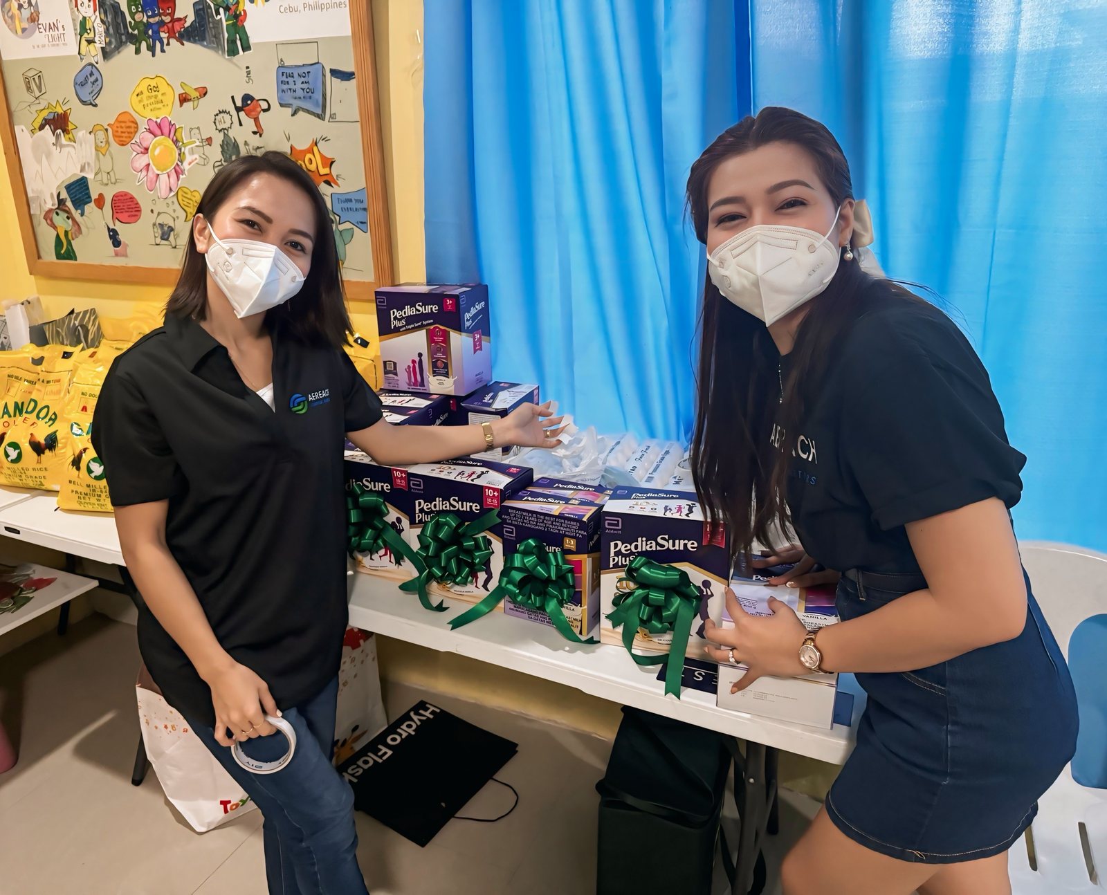 Volunteers preparing gifts by the activity tables.