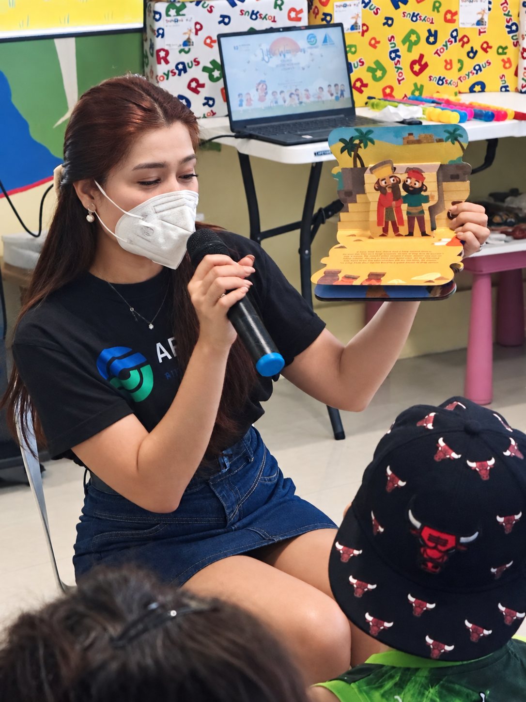A volunteer sharing a handmade gift on the microphone.