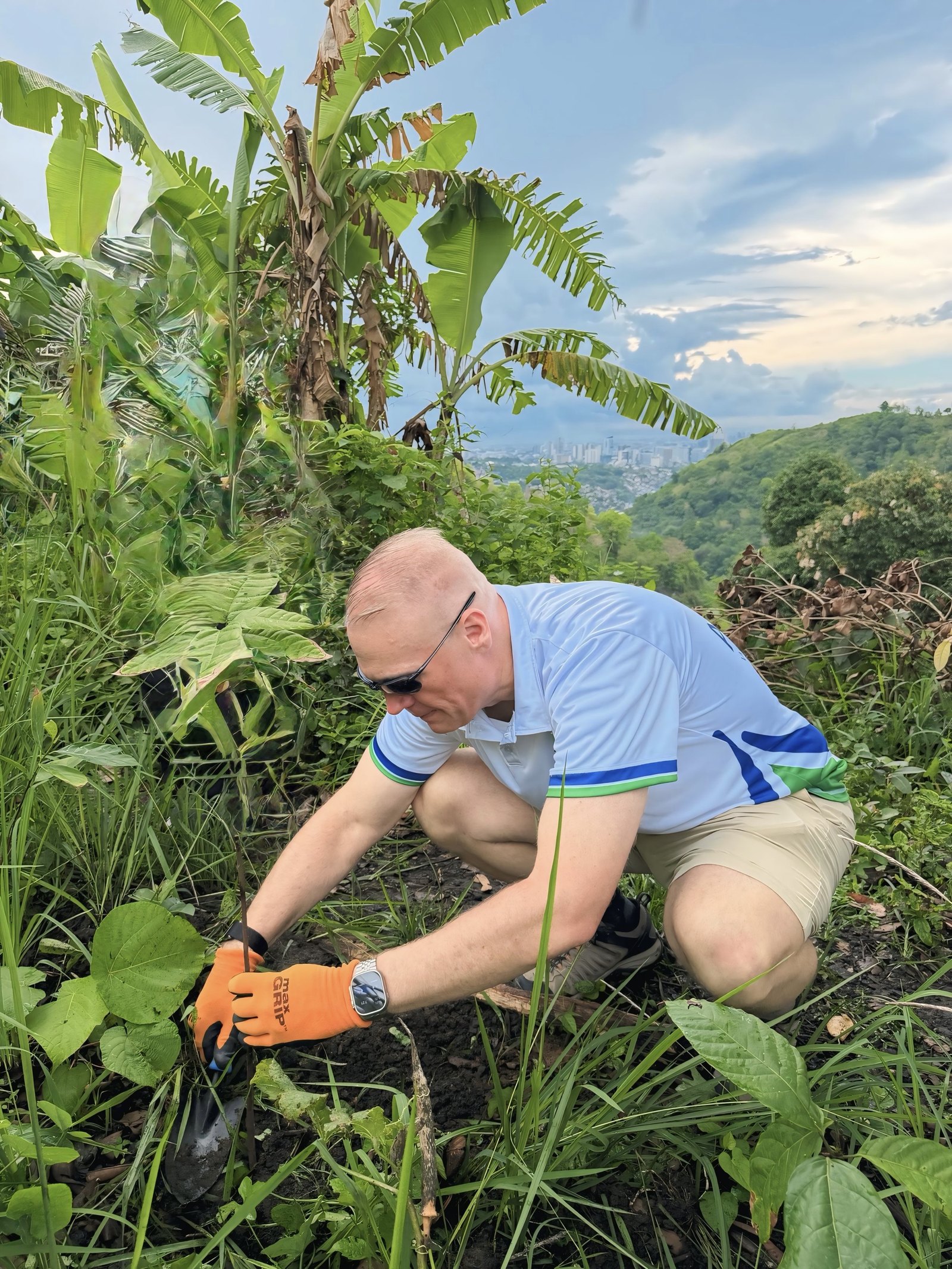Tim Bonnell planting a seedling on the hillside above the city.